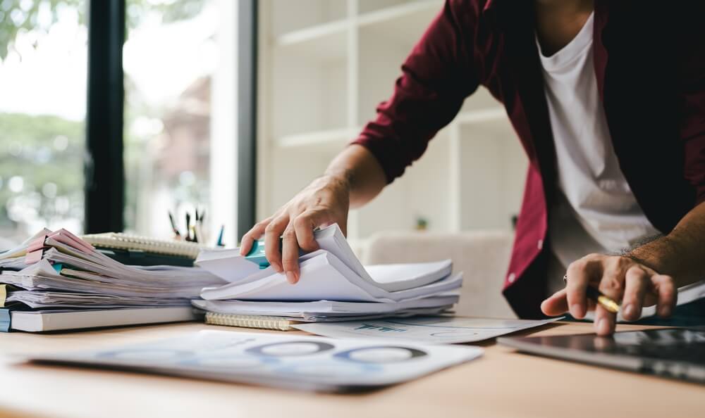 Przedsiębiorca nerwowo wertujący dane finansowe swojej firmy – medifaktor.pl